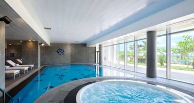 Indoor Pool Area with Whirlpool and Lounge Chairs