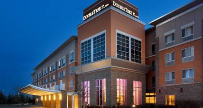 Illuminated Hotel Exterior, Signage, Porte Cochere, Landscaping, and Parking Lot at Dusk