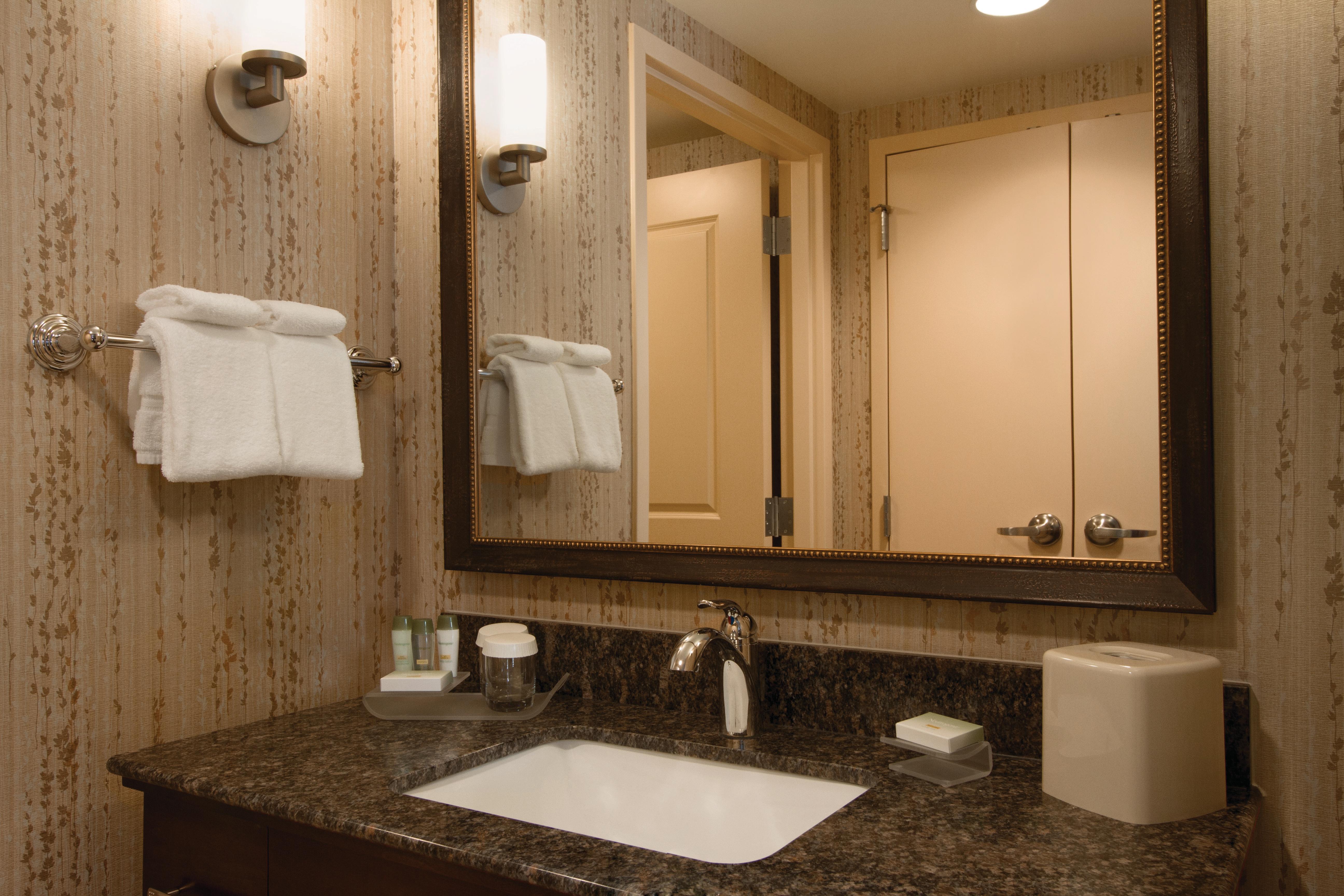 Guest Bathroom With Vanity Mirror, Sink, Towels, and Bath Amenities