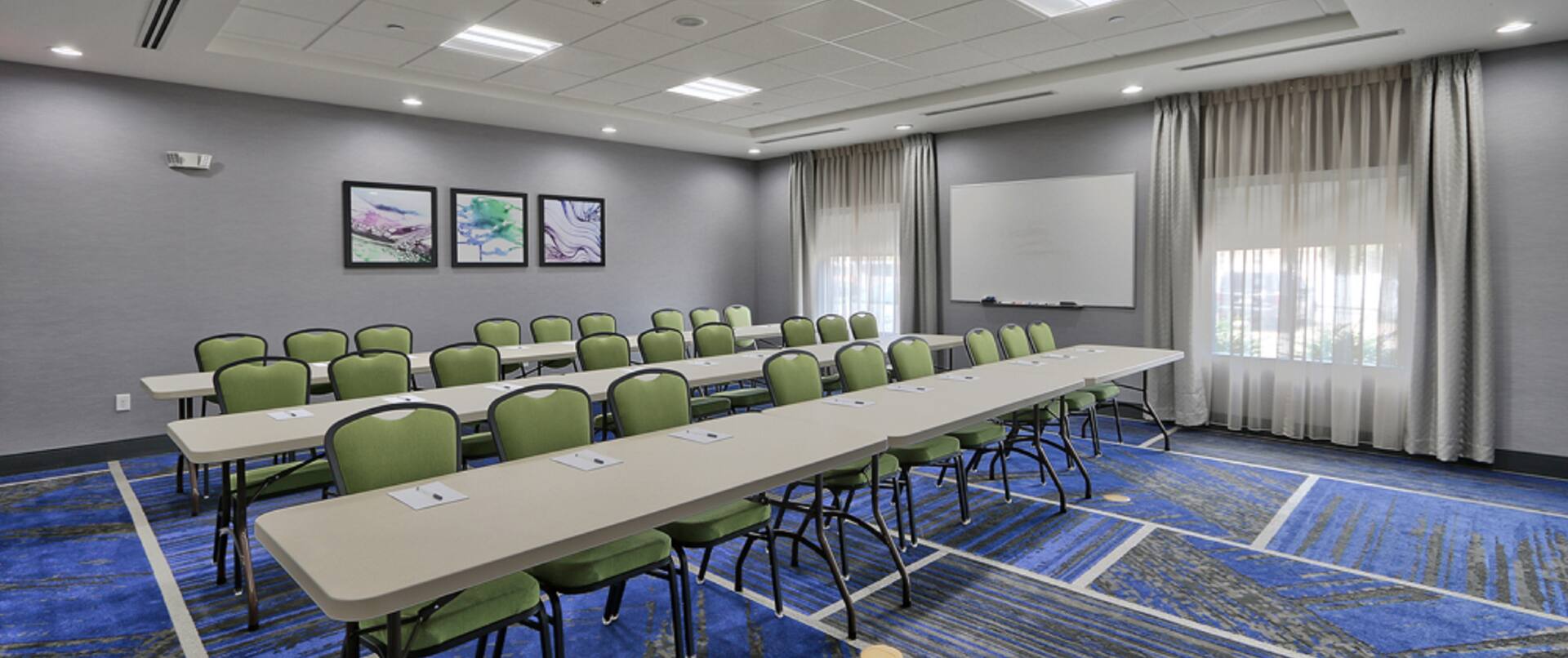 View of Meeting Room from Front of Room with Seats for 27 People, Whiteboard and Windows