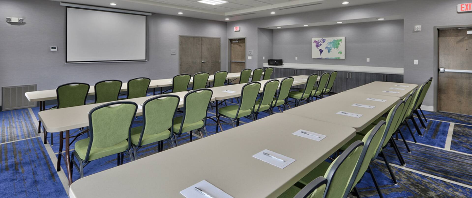 Meeting Room in Classroom Setup with Projector Screen and Seats for 27 People