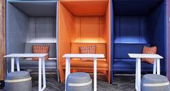 Private Grey. Orange, and Purple Work Alcoves with Table and Soft Seating in the Lobby