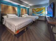 Double Queen Beds with Colorful Artwork and Large HDTV