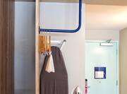 View of Entry Door and Accessible Closet with Ironing Board. Iron and Hangers