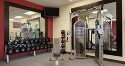 Fitness Center With Large Mirrors, TV, Free Weights, Bench, Weight Balls, and Weight Machine
