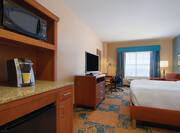 Hospitality Center With Microwave, Keurig, and Mini Fridge, TV, Work Desk, Armchair. Illuminated Lamps, and King Bed