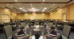 Place Settings Flowers, and Chairs at Banquet Tables With Black Linens in Washita Meeting Room