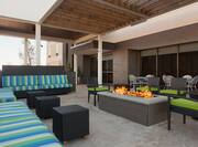 Armchairs With Green Cushions and Striped Sofas by Rectangular Fire Pit on Outdoor Patio
