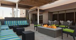 Armchairs With Green Cushions and Striped Sofas by Rectangular Fire Pit on Outdoor Patio