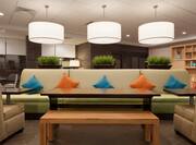 Detailed View of Decorative Lighting Above Large Sofa With Tables, and Armchairs in Oasis Area of Lobby
