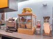 Close Up of Breakfast Counter With Condiments, Toaster, Breads, Bagels, Fruit, Utensils and Napkins