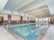 Indoor Pool With Chairs, Tables, Windows, Lounge Chairs, Towel Station, and Accessible Ramp