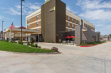 Angled View of Main Exterior Entrance, Driveway, Flagpole, Landscaping, Signage, and Parking Lot 