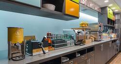 Detailed View of Waffle Station and "Inspired Table" Signage Above Counter of Breakfast Area