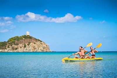 Shot of people in Canoe on water with island behind them