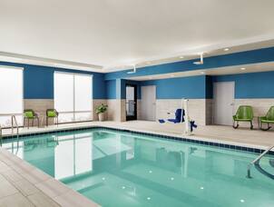 Spacious indoor pool featuring convenient accessible chair lift and ample seating.