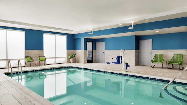 Spacious indoor pool featuring convenient accessible chair lift and ample seating.