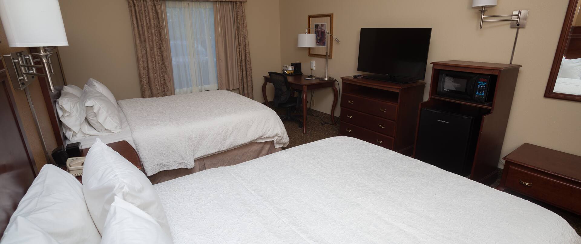 Two Beds HDTV Desk and Microwave in a Hotel Guest Room