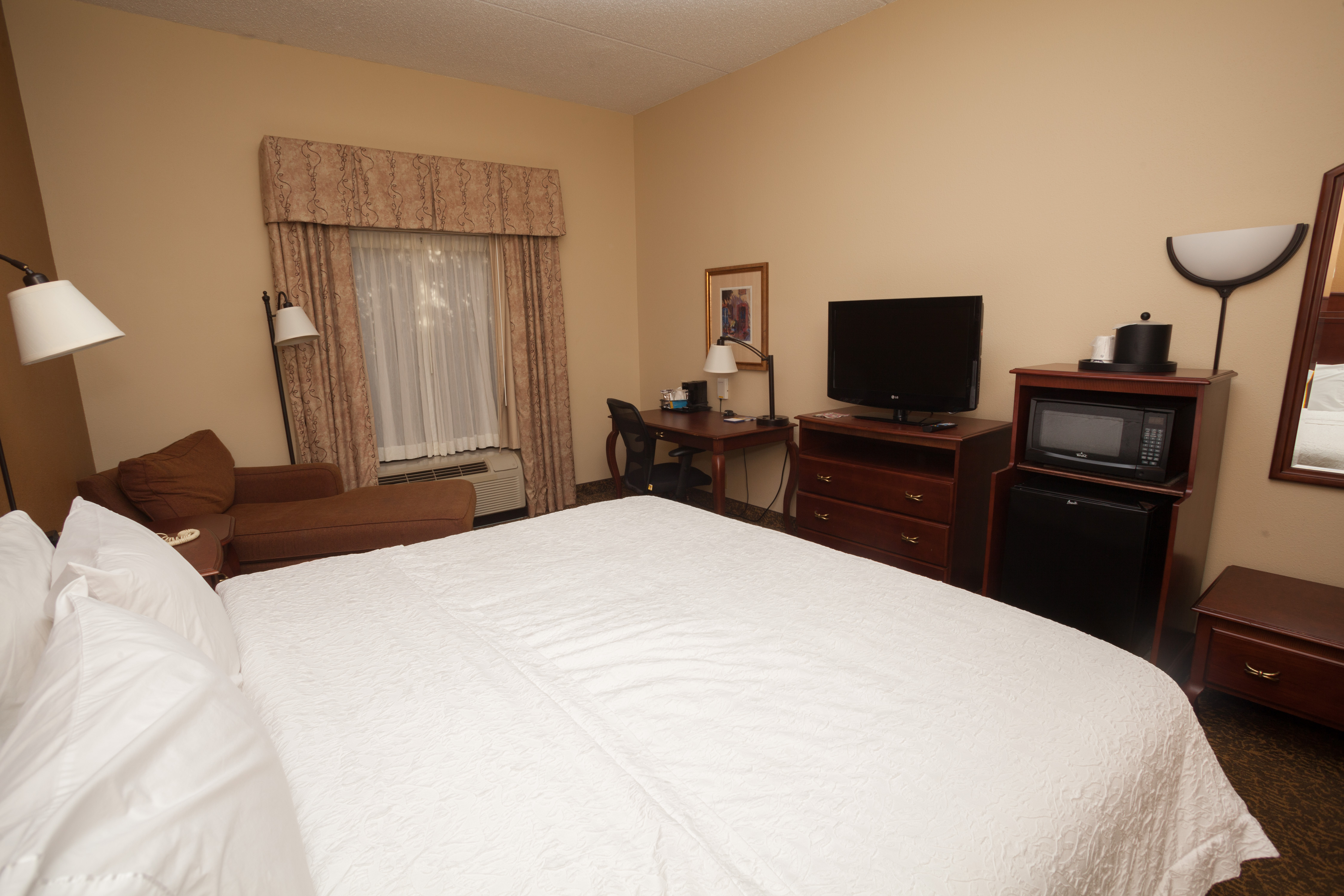 Large Bed in a Guest Room with Microwave HDTV and Desk Area