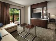 a suite living area with a tv and half wall room divider