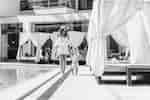 Woman walking along the side of the pool holding a child's hand