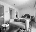 스튜디오 내 대형 침대 및 빨간색 베개 2개가 있는 탄 소파를 갖춘 침실