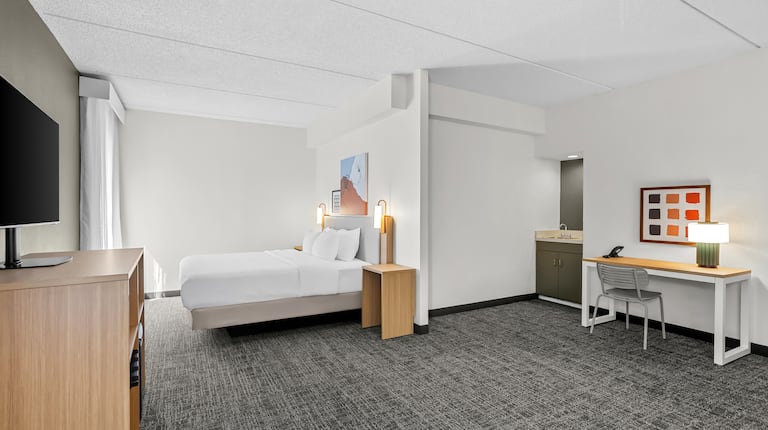 living area of bedroom with work desk and bedroom