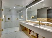 Dual Vanity Area with Large Lit Mirror and Glass Door Shower