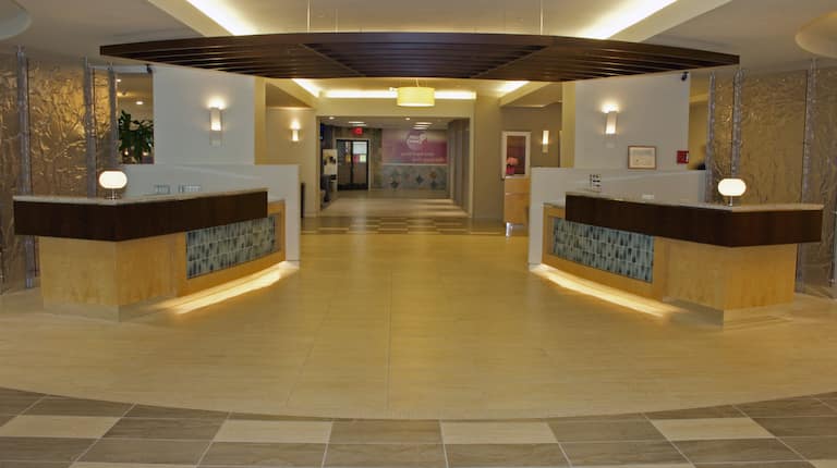 Reception Desks With Illuminated Lamps and View Down Lobby Corridor