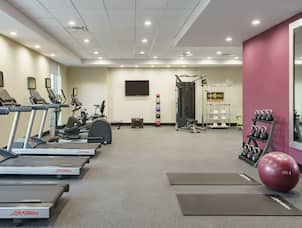 Convenient on-site fitness center fully equipped with cardio machines, free weights, and yoga mats.