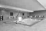 Spacious indoor pool featuring ample seating, complimentary towels, and convenient accessible chair lift.