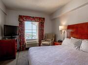 Guestroom Suite with King Bed, Lounge Area, Room Technology, and Outside View