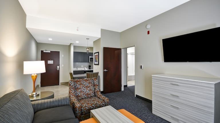 Homewood Suites by Hilton Orlando Theme Parks - Living Room with Sofa, Dresser, TV, Chair and Tables
