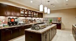 Breakfast serving area with buffet trays, coffee, juice, pastries, fruits, and dining amenities