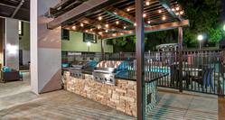 Outdoor patio with BBQ grills under pavilion at night
