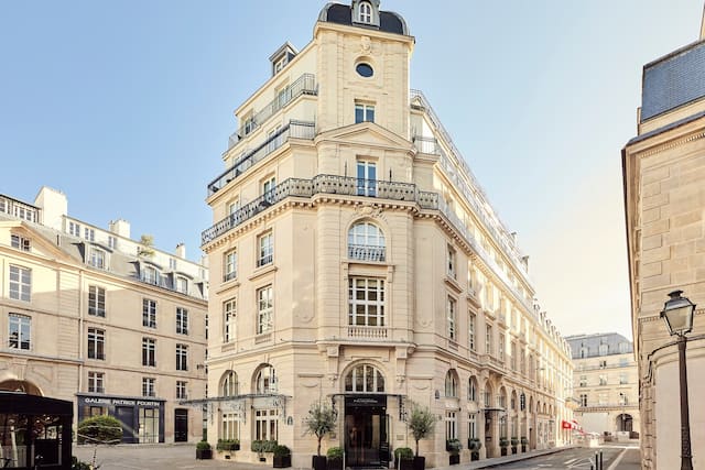 Historic hotel facade surrounded by other historic buildings in blonde sandstone