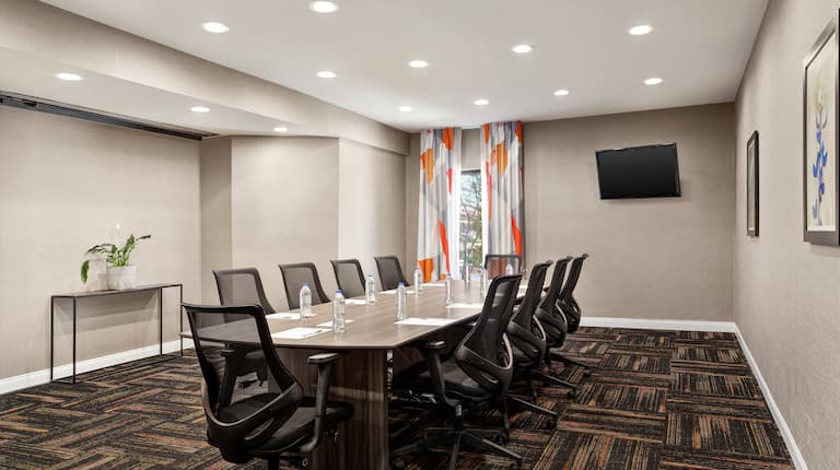 Spacious on-site meeting room featuring large boardroom table and TV.