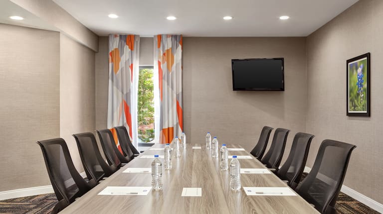 Spacious on-site meeting room featuring large boardroom table and TV.
