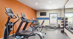 Convenient on-site fitness center featuring cardio machines and free weights.