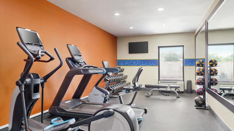 Convenient on-site fitness center featuring cardio machines and free weights.