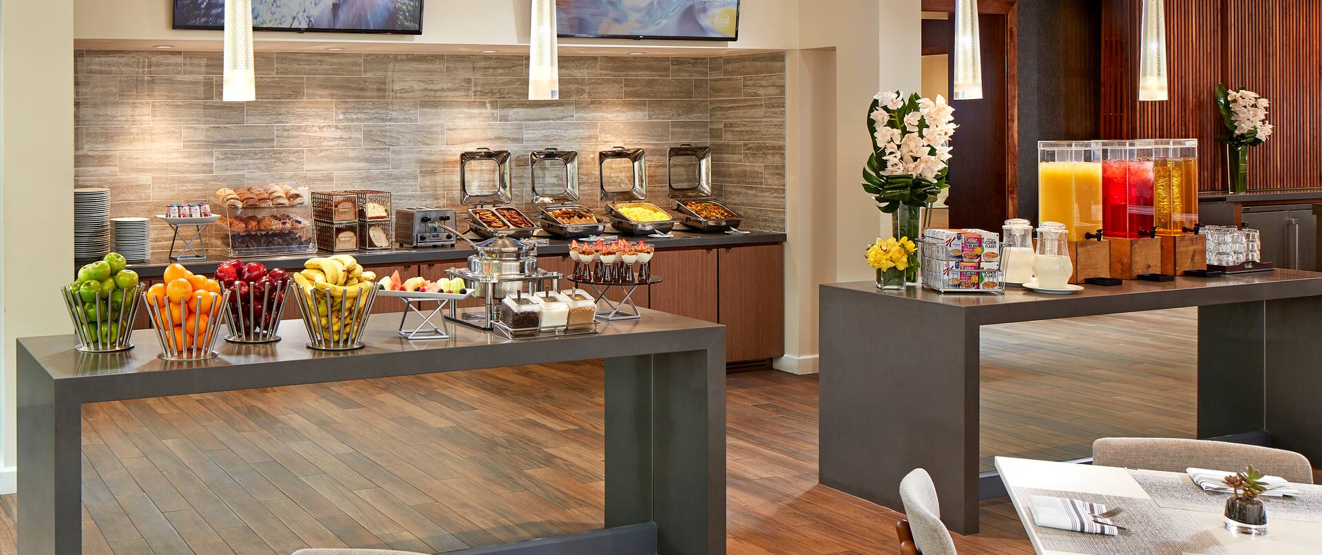 Breakfast Buffet Area with Tables and Counters with Food and Drinks