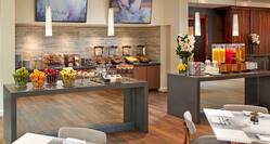 Breakfast Buffet Area with Tables and Counters with Food and Drinks