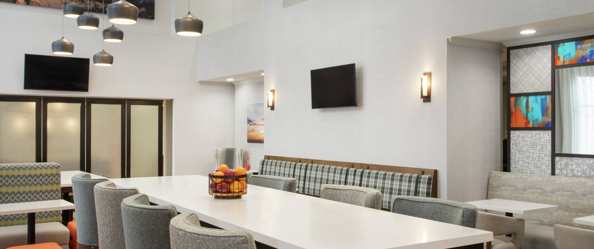 Spacious hotel lobby featuring large communal table, ample soft seating, and stylish design.