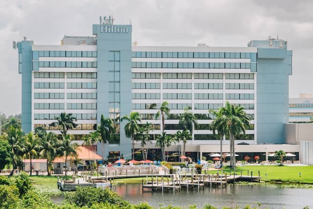 Hotel exterior with trees and small lake