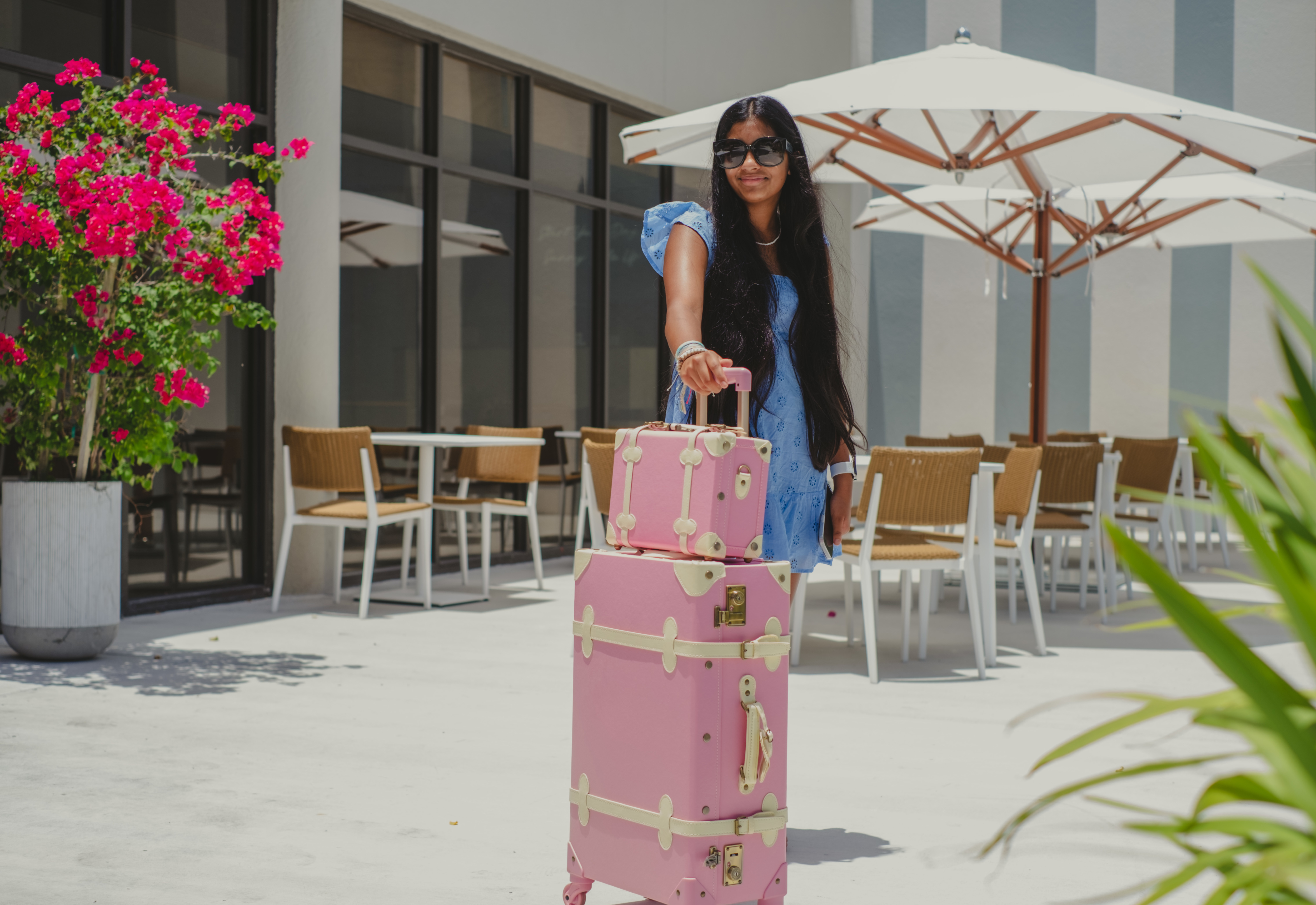 Woman standing outside hotel with luggage
