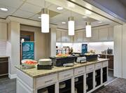Food and Beverage serving area with food selections coffee, juice, snacks, vegetables, and dining amenities