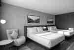 Two Queen Bed Guestroom with Lounge Chair and Accent Table