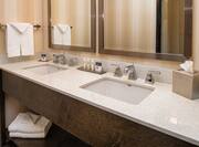 Detailed View of Bathroom Vanity Mirrors, Double Sinks, Fresh Towels, Toiletries, and Amenities in Double Queen Bathroom