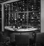 Bar mit Weinflaschen und Stühlen