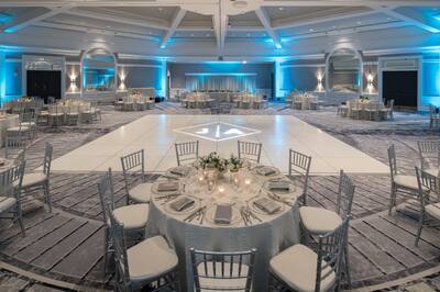 Ballroom setup for wedding with circular tables around dancefloor